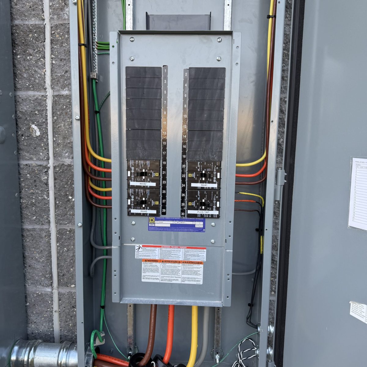Commercial electrician installing electrical panel in Connecticut business facility